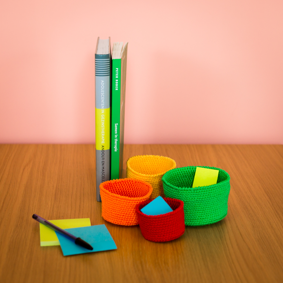 Afbeelding van de boeken Systeemtherapie en Geweldloos Verzet & Verbindend Gezag, samen met mandjes die deel uitmaken van de methode Geweldloos Verzet. Deze boeken en methoden worden gebruikt in mijn praktijk als familiepsycholoog om gezinsdynamieken te verbeteren en gezonde communicatie te bevorderen.